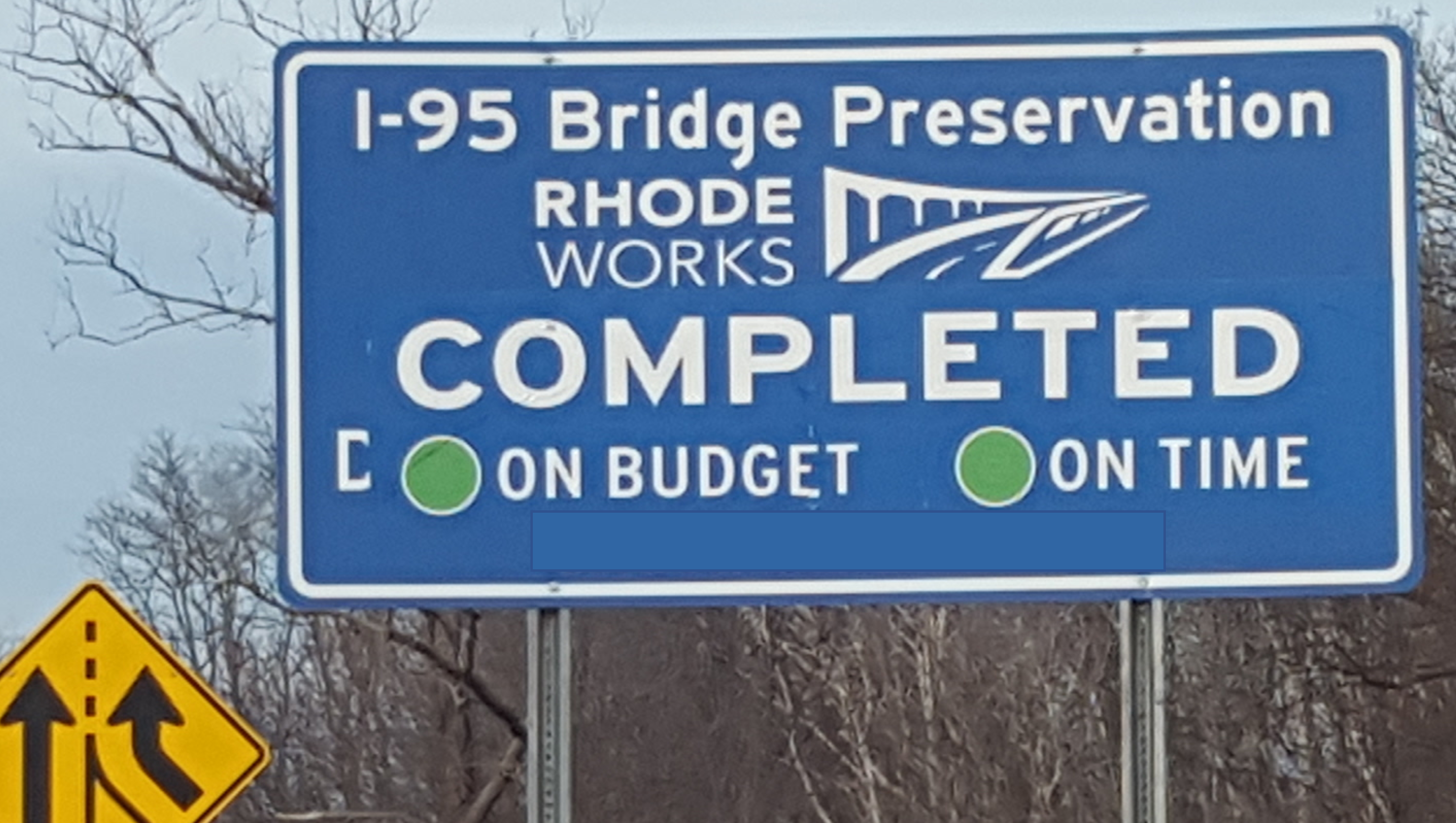 Blue highway sign informing a Bridge Construction Project that was completed on time and on budget. 